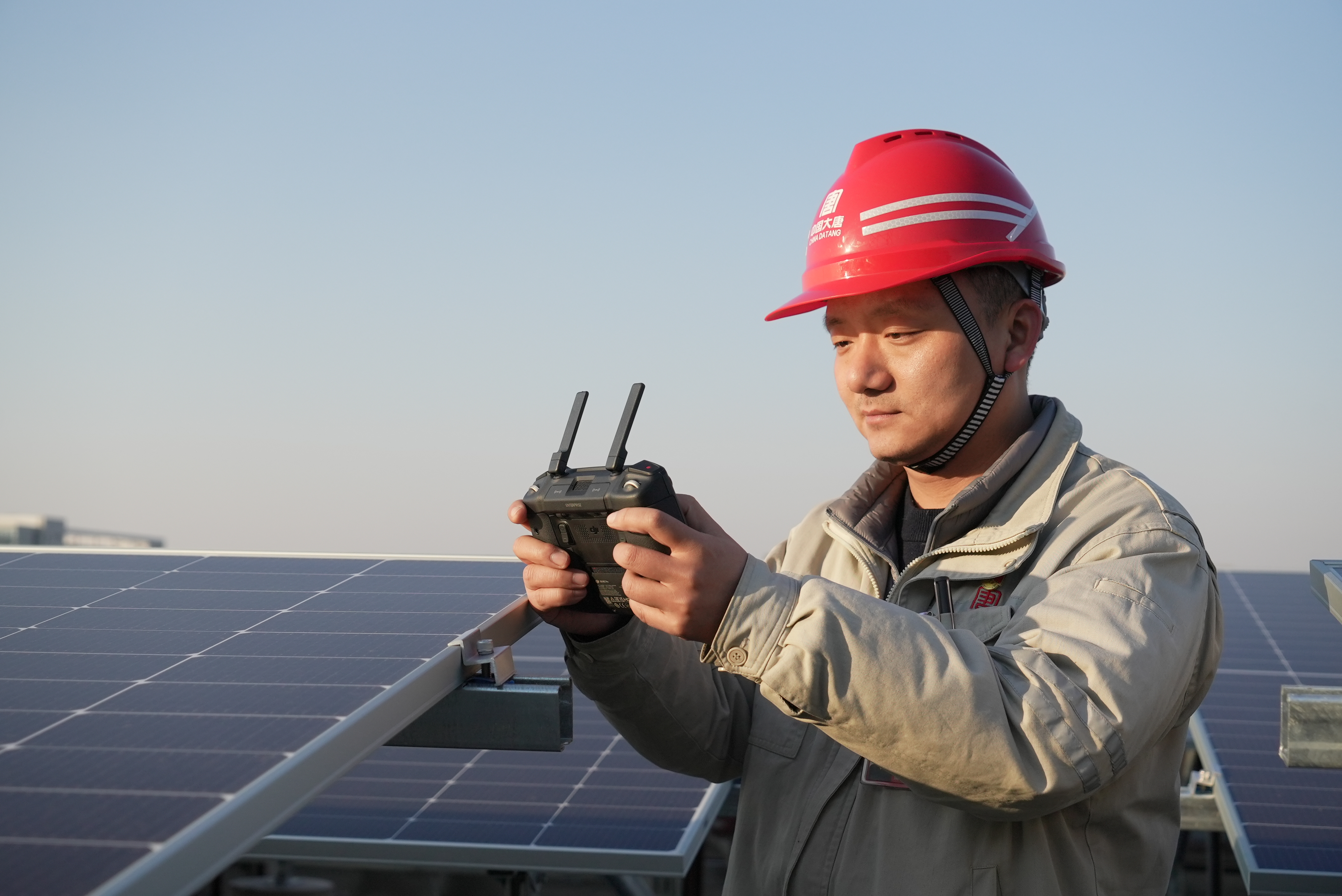 3.黃鵬飛使用無人機察看光伏建設現場.jpg